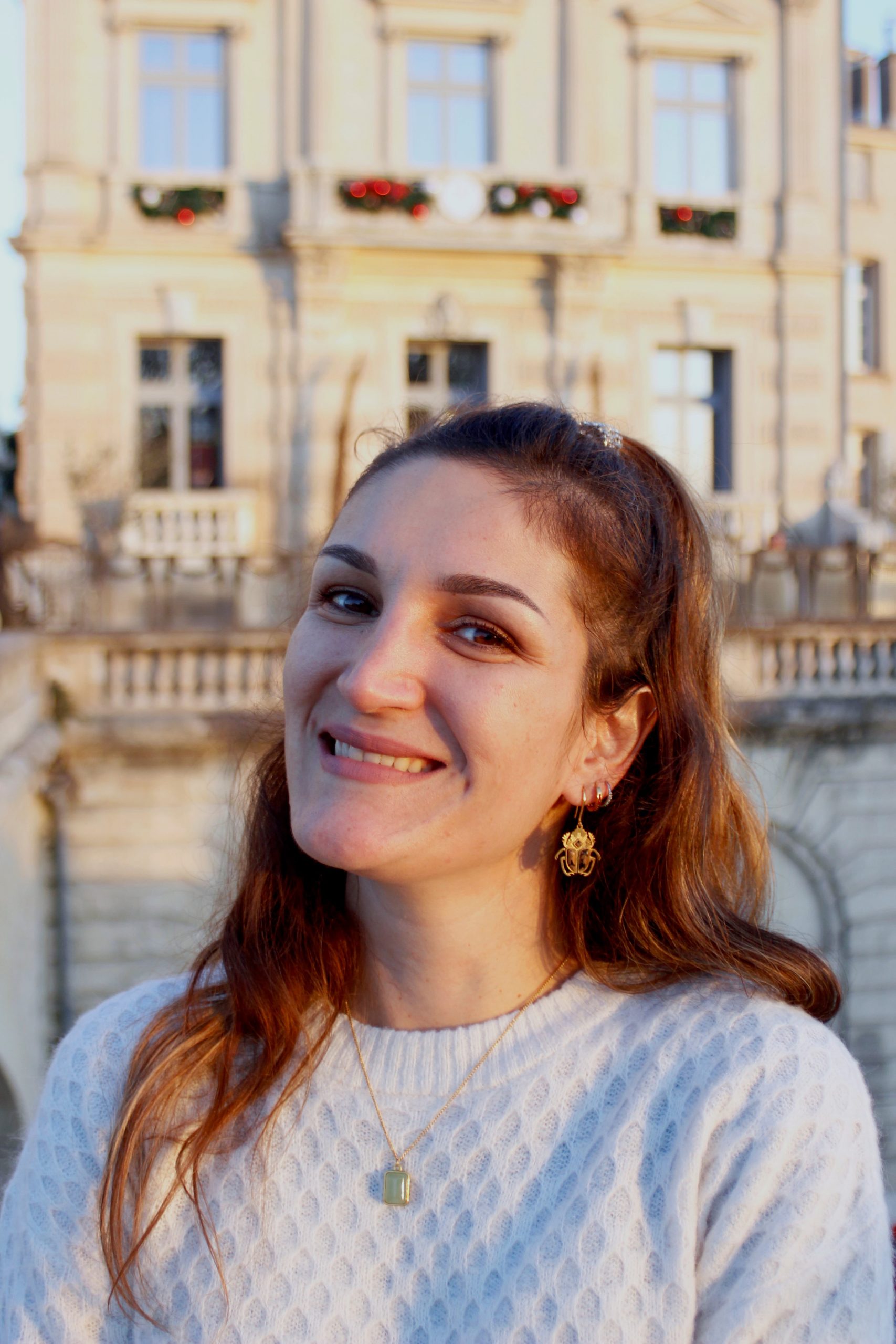 A propos 3 Une femme avec des boucles d'oreille qui sourit