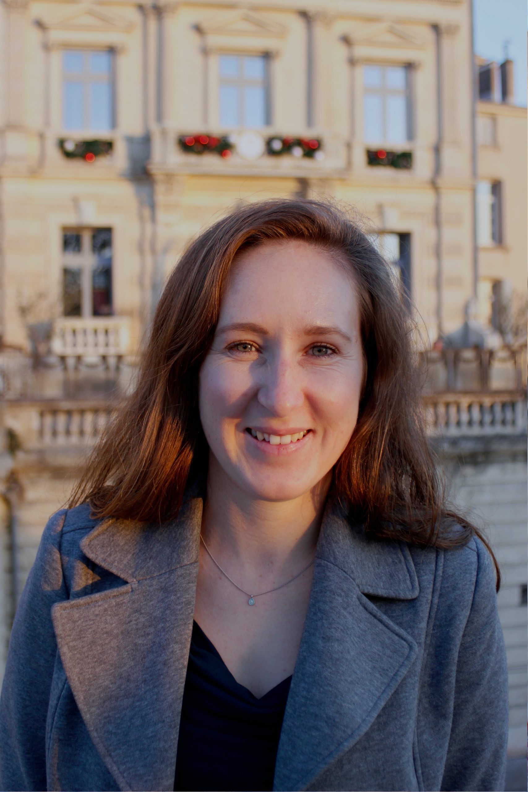 A propos 4 Une femme au manteau gris qui sourit