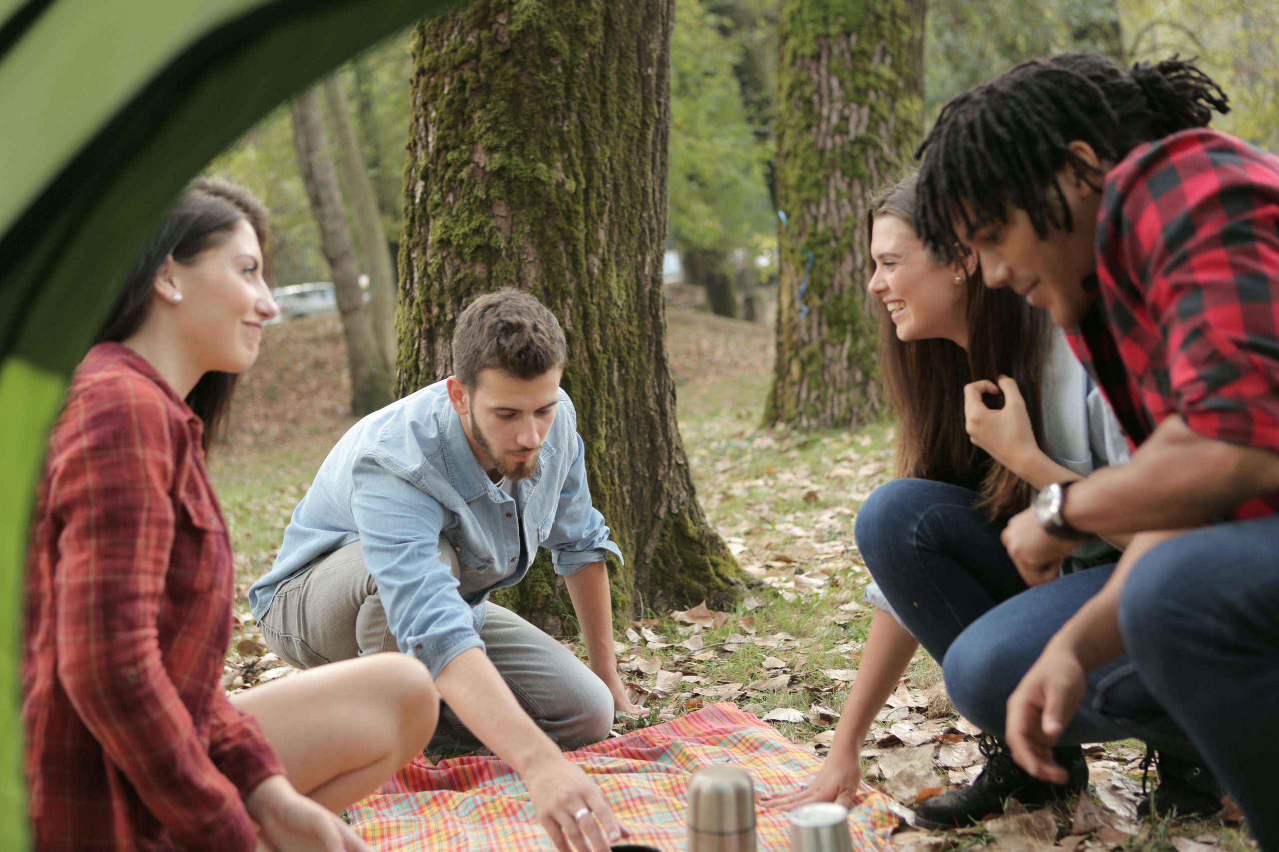 un groupe assis par terre en train de faire une activité manuelle. contactez nous
